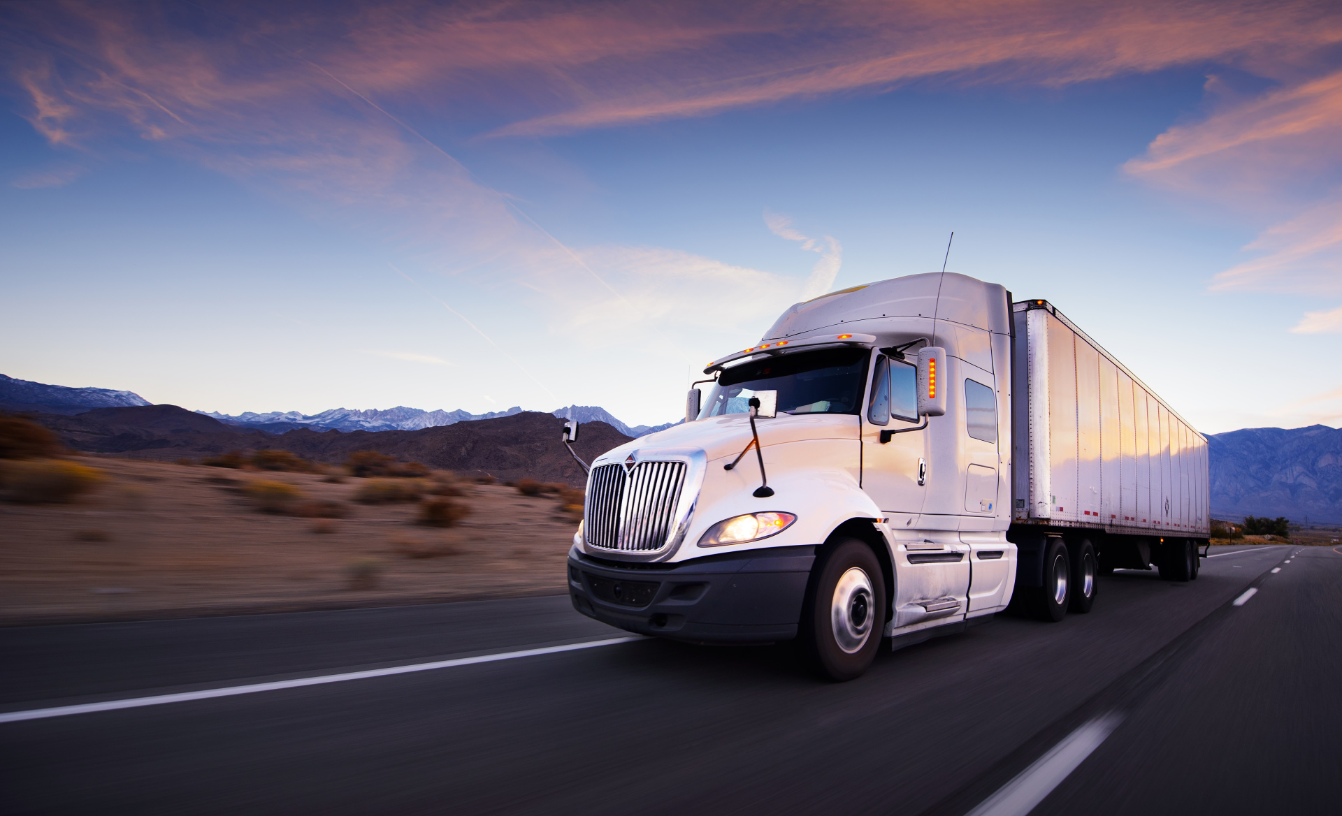 Truck and highway at sunset - transportation background